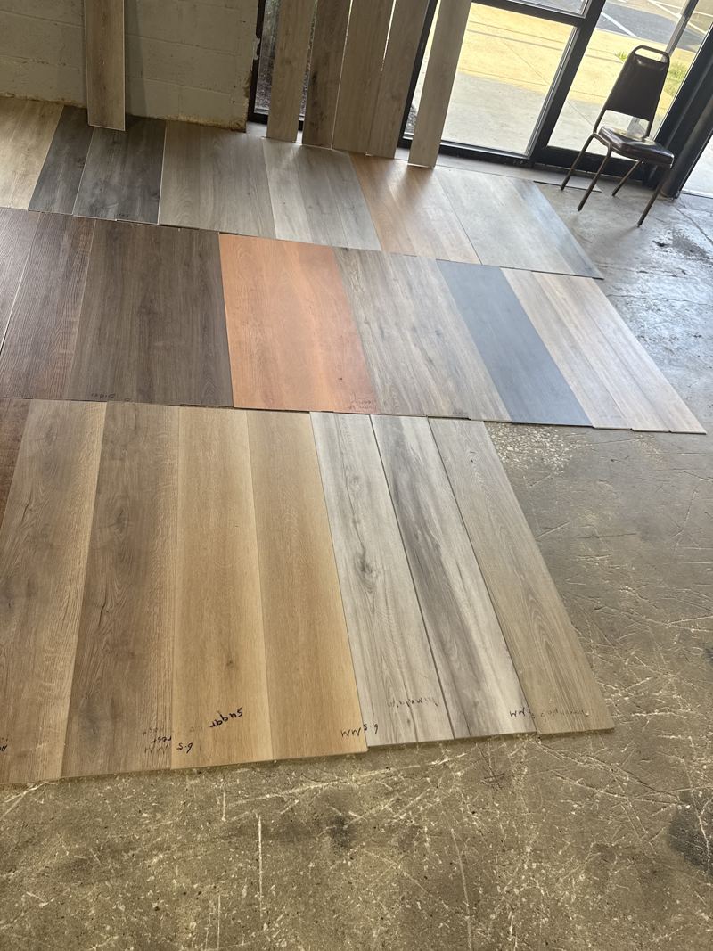 LVP planks in several colors laid out side by side on the warehouse floor